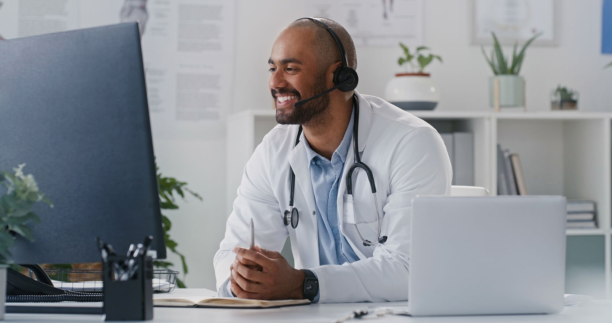 A medical professional wearing a headset and smiling.