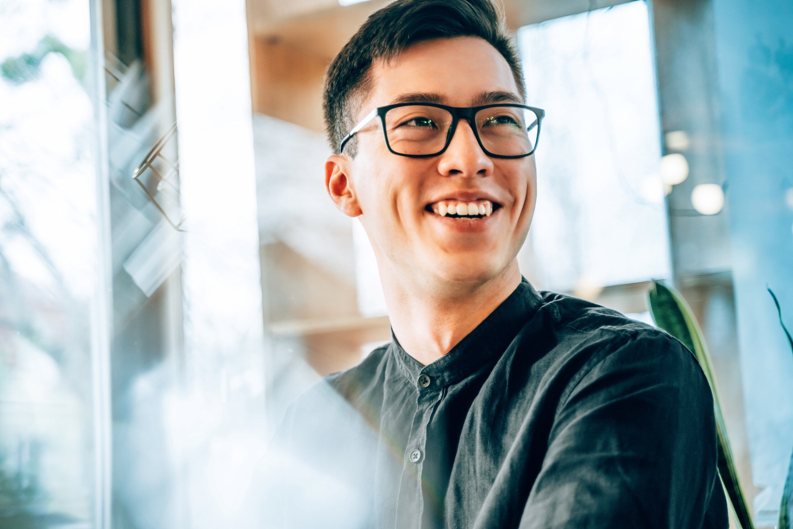 Man in glasses and button up shirt, smiling.