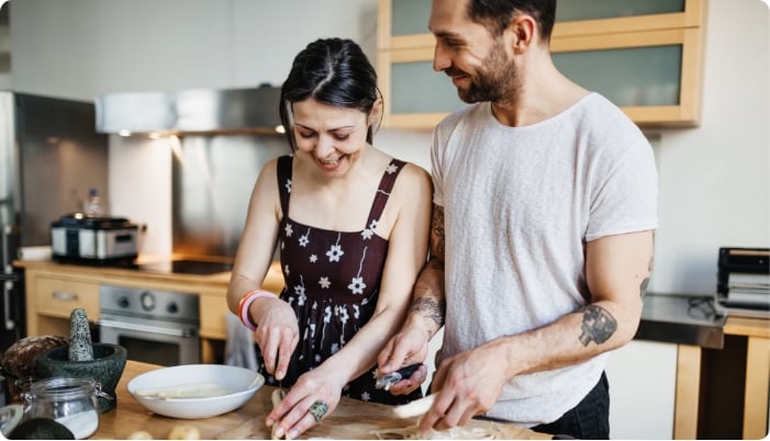 A happy couple cooking in their kitchen.
