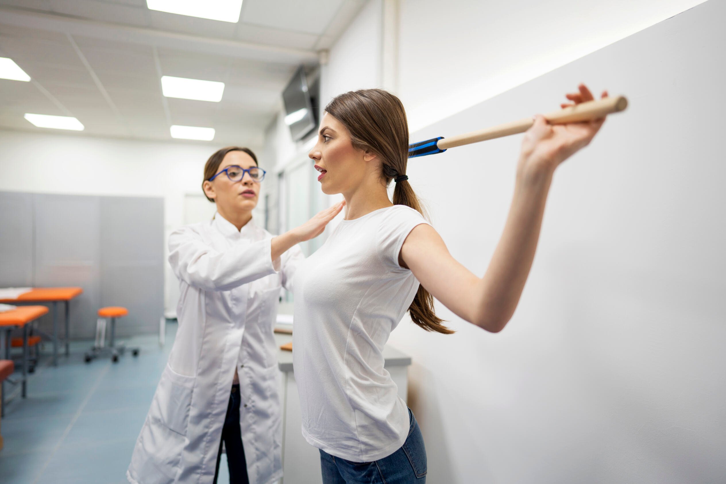 A doctor helping a woman with posture correction.